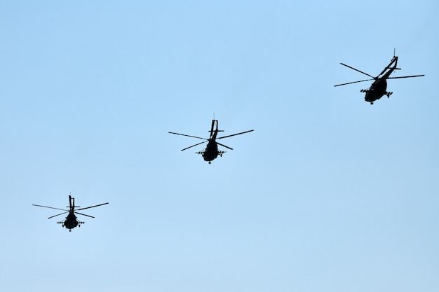 Militärhubschrauber, die in strahlend blauem Himmel fliegen, führen Demonstrationsflug, Luftwaffe, Kopierraum durch. Gruppenkampfhubschrauber, Kunstflugstaffel führt Flug bei Flugschau durch