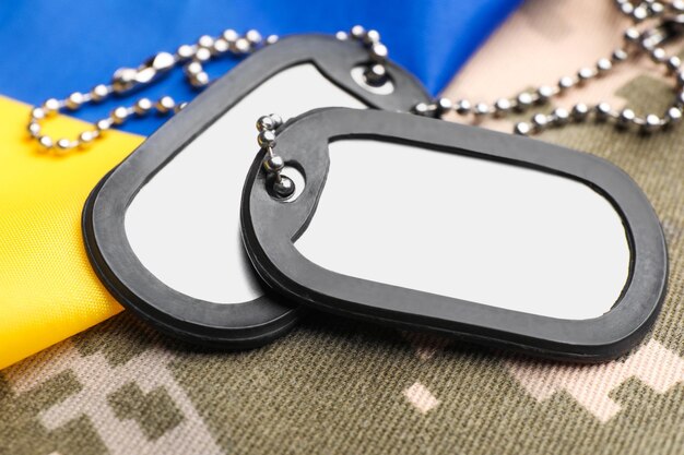 Militärische ID-Tags und ukrainische Flagge auf Pixel-Camouflage-Nahaufnahme