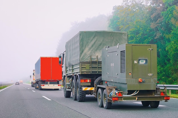 Militärlastwagen mit Anhänger auf der Asphaltstraße in Slowenien.