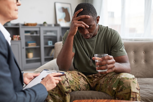 Militar africano bebendo água e falando sobre seus problemas com psicólogo