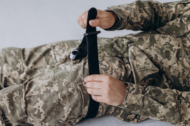 Foto un militar demuestra un torniquete médico de combate para detener la sangre durante las instrucciones de primeros auxilios para equipos tácticos de combate