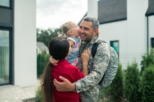 Militar emocional. Militar emocional abraçando sua esposa e filha depois de voltar para casa