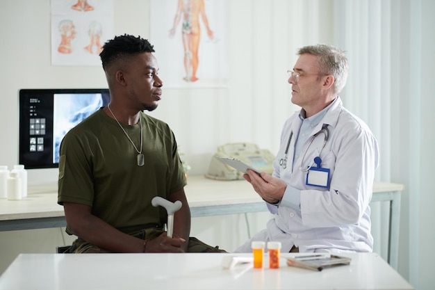 Militar hombre hablando con médico