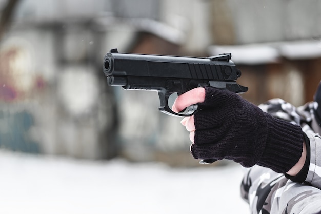 Un militar con una pistola junto a edificios antiguos