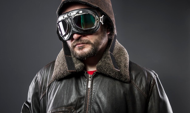 Militar, recreación de la Segunda Guerra Mundial, viejo piloto de avión con chaqueta de cuero marrón, gorra de avidor y anteojos grandes