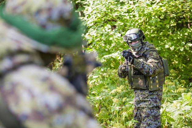 Militares en el bosque con rifles de asalto Kalashnikov. Acciones militares