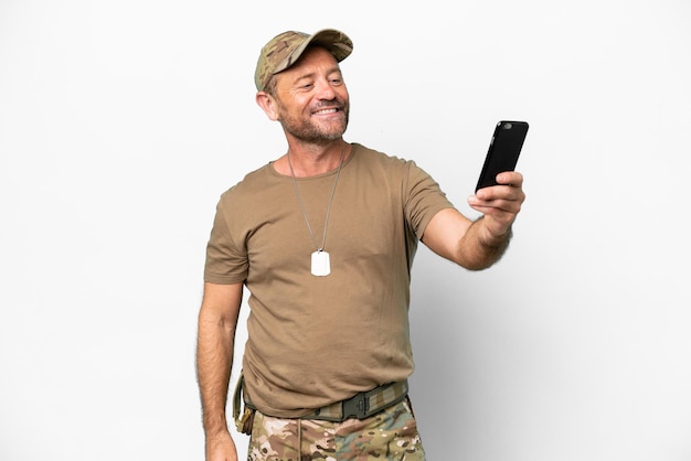 Militares de mediana edad con placa de identificación aislada de fondo blanco haciendo un selfie