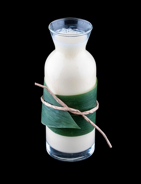 Milk-shake com leite de coco em uma garrafa de vidro em um fundo escuro
