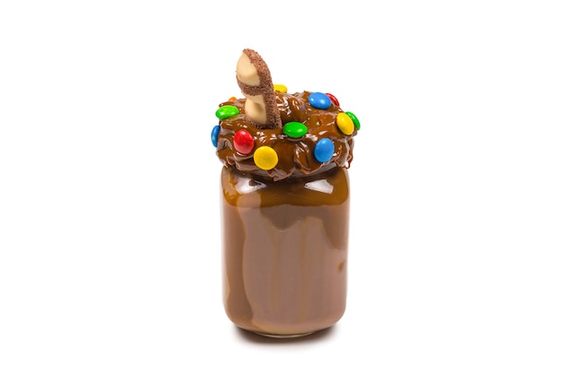 Milk-shake de chocolate com chantilly, biscoitos, waffles, servido em pote de vidro. Batido doce "anormal ou louco". Isolado. Espaço para texto ou desenho.