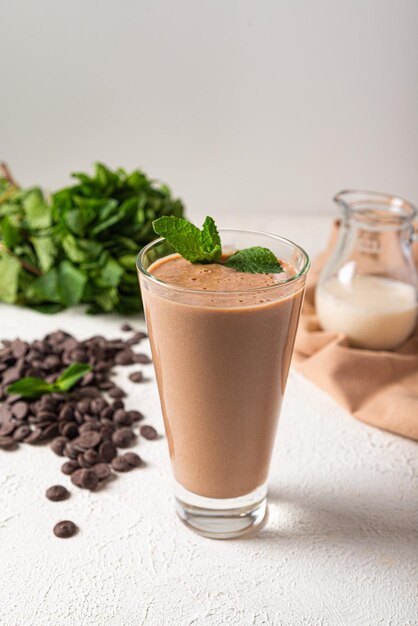 Milk-shake de proteína de chocolate em fundo de cozinha de vidro branco