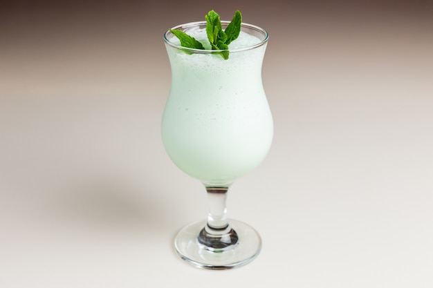 Milk-shake verde brilhante em um copo de furacão
