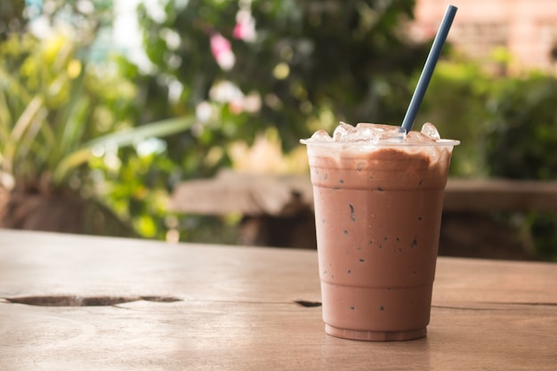 Milkshake de chocolate gelado, refresco de verão bebe em fundo de madeira no café