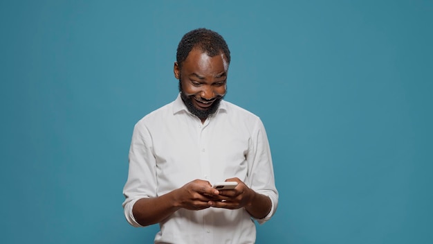 Millennial-Arbeiter, der die Social-Media-App verwendet, um Textnachrichten auf dem Smartphone zu senden und im Online-SMS-Chat zu sprechen. Junger Erwachsener, der im Internet surft und auf dem Touchscreen des Mobiltelefons tippt. Drahtloses Netzwerk