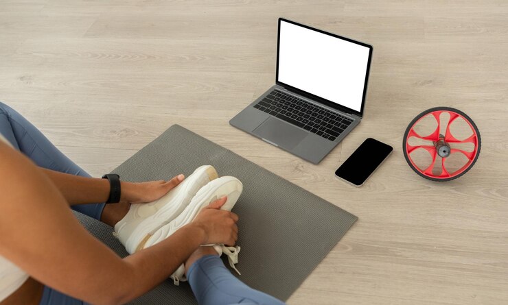 Foto millennial mujer latina blogger en ropa deportiva ver video blog de fitness en el teléfono de la computadora con vacío