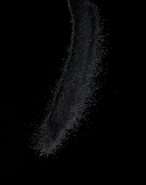 Millionen von schwarzen Sand-Explosionen Foto-Bild von fallendem Sand fliegen Gefrierschuss auf schwarzem Hintergrund isolierte Überlagerung winziger feiner Sandstaub Magnet als Partikel zerfallen Wissenschaft