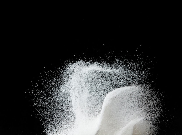 Millionen weißer Sandexplosion Fotobild eines herabstürzenden Schauers, Schnee, schwerer Schneefall, Sturm, fliegender Freeze-Schuss auf schwarzem Hintergrund, isolierte Überlagerung. Winzige feine Salzsande als Teilchenwissenschaft