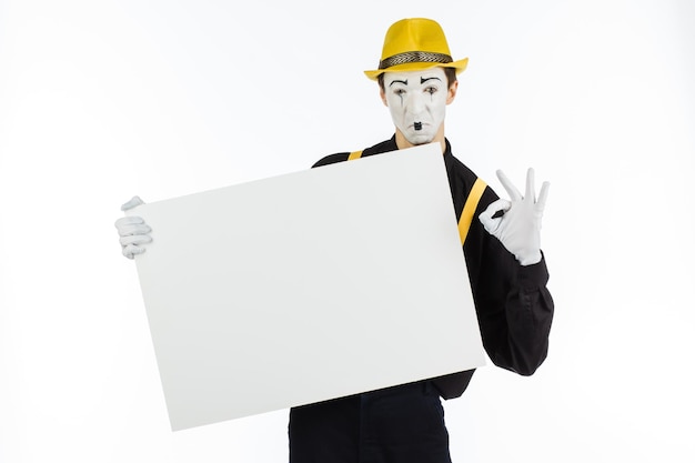 MIME actor joven sosteniendo un panel blanco con espacio para texto