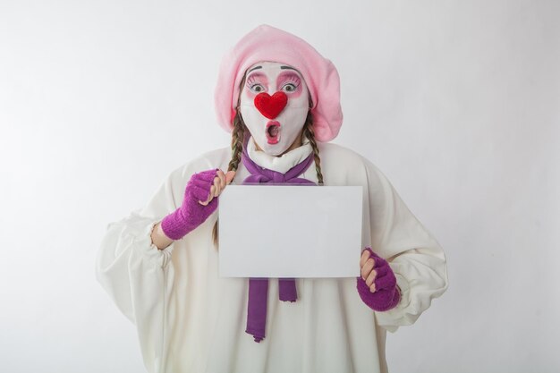 Mime chica con un letrero blanco para la inscripción.