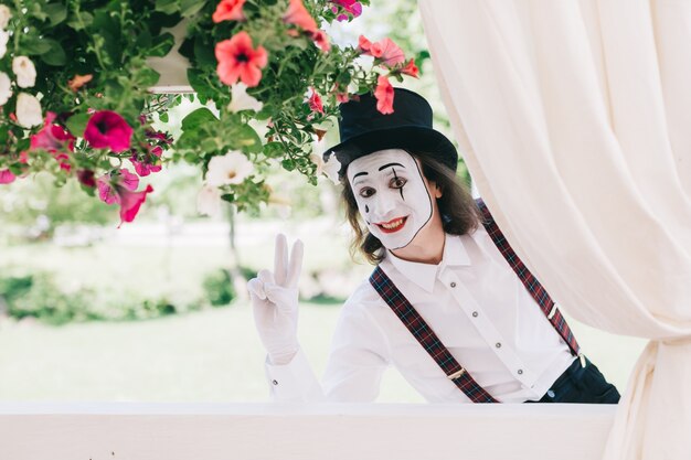 Mime posando ao lado de algumas flores