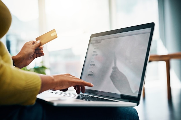 Mime-se com a conveniência das compras online Foto recortada de uma mulher usando seu cartão de crédito para fazer um pagamento online em casa