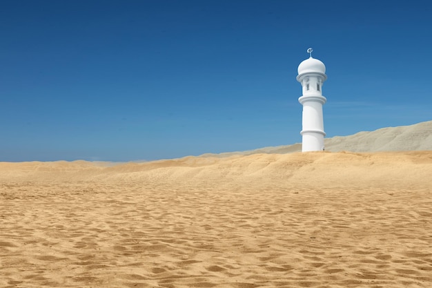 Minarete da mesquita no deserto com fundo de céu azul