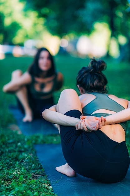 Mindfulness e meditação mulheres fazendo ioga à beira do lago