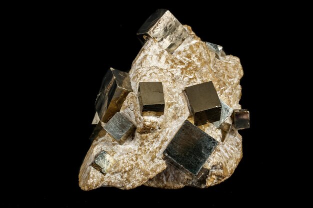 Mineral de pirita de pedra macro na rocha em um fundo preto