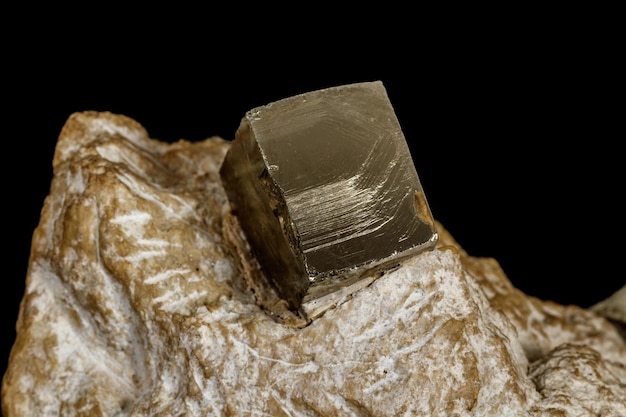 Mineral de pirita de pedra macro na rocha em um fundo preto