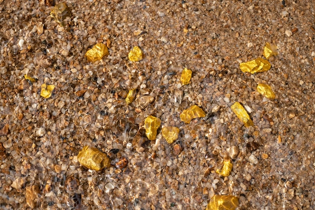 Mineral de pepita de oro puro encontrado en mina con fuentes naturales bajo el agua