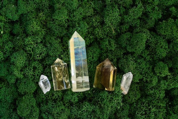 Los minerales de las piedras preciosas se mezclan en el misterioso fondo de musgo del bosque natural, los cristales de cuarzo y calcita cierran la vista superior Roca curativa mágica para la brujería ritual de cristal de Reiki