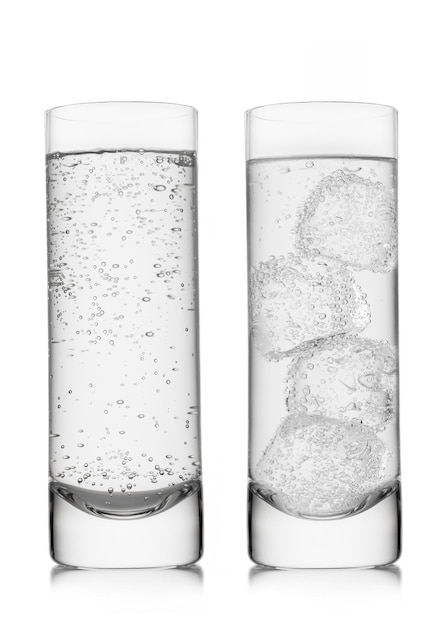 Mineralwasser mit eiswürfeln auf weiß in highballgläsern