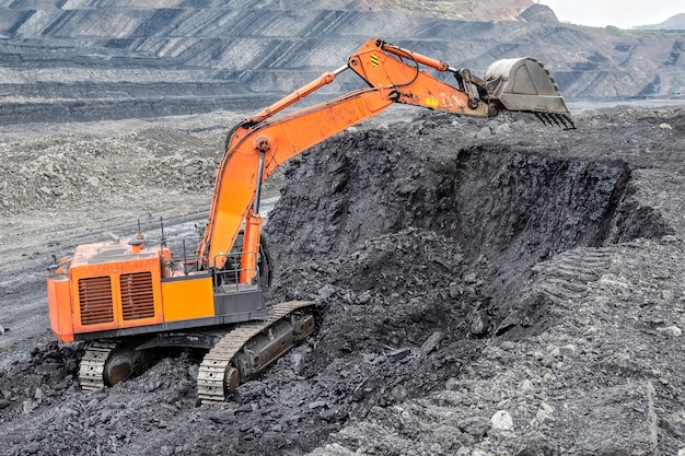 Minería de carbón con excavadora hidráulica. La minería del carbón desde una cara vertical, un método de minería a cielo abierto.