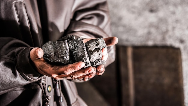 Minería de carbón minero en manos del hombre de fondo de carbón. Idea de imagen sobre minería de carbón o ener.