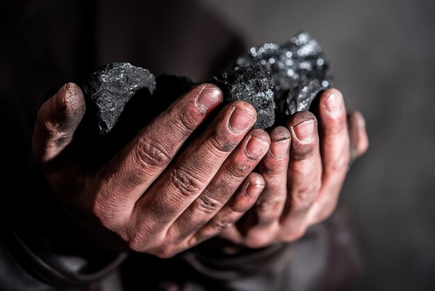 Minería de carbón minero en manos del hombre de fondo de carbón. Idea de imagen sobre minería de carbón o ener.