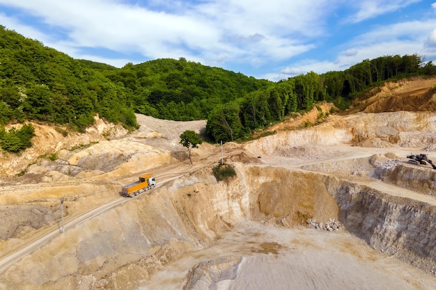 Minería a cielo abierto de materiales de piedra arenisca de construcción con excavadoras y volquetes