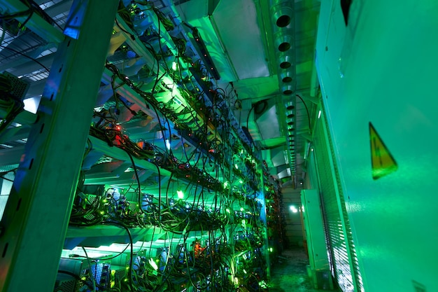 Los mineros de Bitcoin en granjas grandes equipos de minería ASIC en bastidores de soporte minan criptomoneda en contenedores de acero Aplicación de la tecnología Blockchain centro de datos de circuitos integrados específicos Luces de salas de servidores