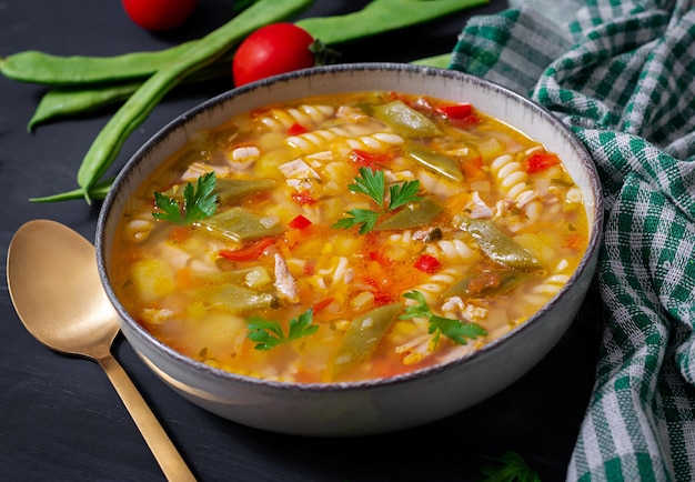 Minestrone italienische Gemüsesuppe mit Nudeln auf schwarzem Tisch