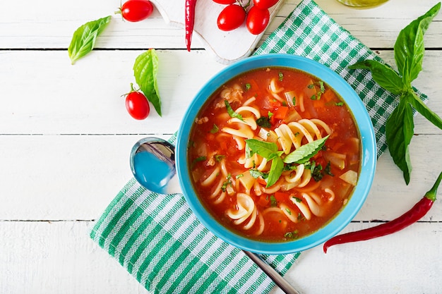 Minestrone, italienische Gemüsesuppe mit Nudeln. Tomatensuppe. Veganes Essen. Ansicht von oben. Flach liegen.