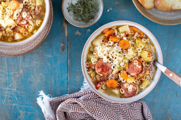 Minestrone-Suppe in einer Pfanne auf einem hellen Tisch Draufsicht Italienische Suppe mit Nudeln und Gemüse der Saison Köstliches vegetarisches Essenskonzept