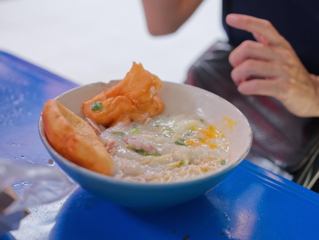 Mingau chinês com ovo em um intestino com conjunto de café da manhã do conceito de rosquinha chinesa