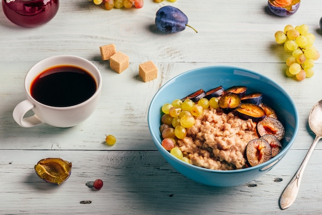 Mingau com ameixa fresca, uvas verdes e café