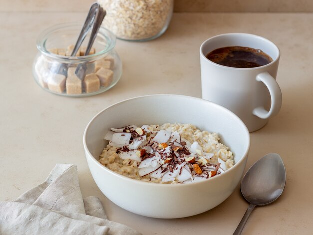 Foto mingau de aveia com amêndoas, coco e chocolate. alimentação saudável. comida vegetariana. café da manhã. dieta.