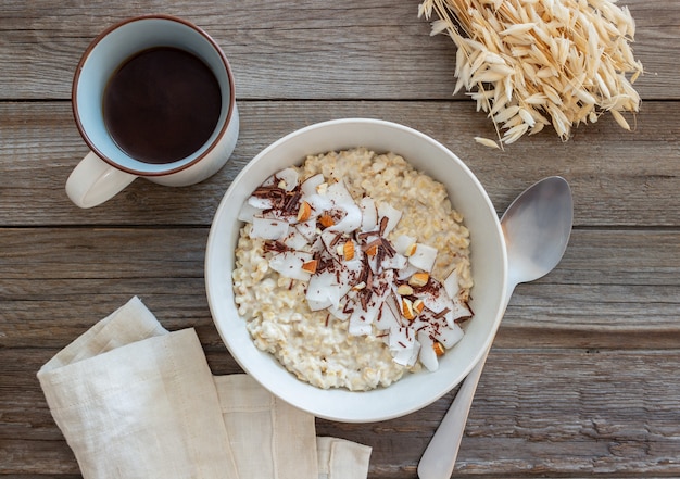 Mingau de aveia com amêndoas, coco e chocolate. Alimentação saudável. Comida vegetariana. Café da manhã. Dieta.