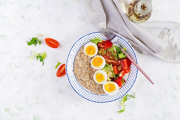 Mingau de aveia com ovo cozido, tomate cereja, pimentão e alface Comida equilibrada saudável Vista superior em cima