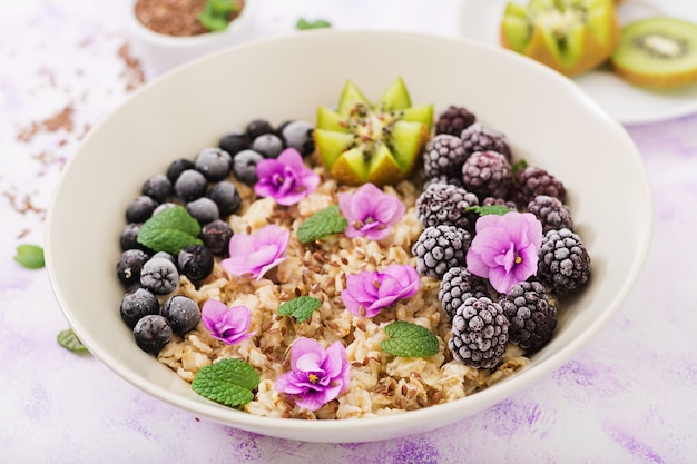 Foto mingau de aveia saboroso e saudável com frutas, bagas e sementes de linho. café da manhã saudável.