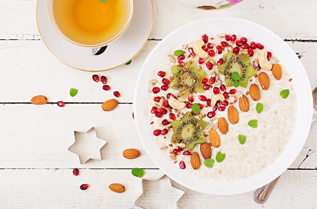 Mingau de aveia saboroso e saudável com kiwi, romã e sementes. Café da manhã saudável. Comida de fitness. Nutrição apropriada. Vista do topo