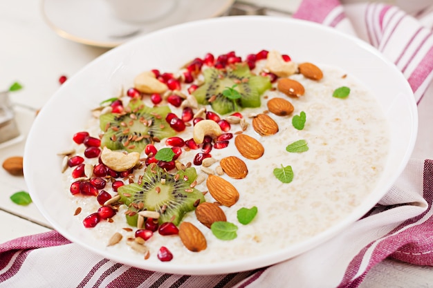 Mingau de aveia saboroso e saudável com kiwi, romã e sementes. Café da manhã saudável. Comida de fitness. Nutrição apropriada.