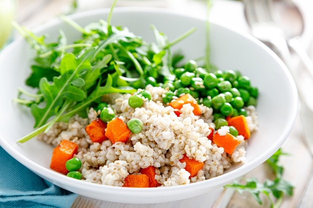 Mingau de cevada com abóbora assada com ervilhas verdes e salada de rúcula fresca