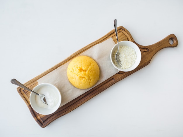 Mingau de milho romeno mamalyga com queijo e creme de leite em um carrinho de madeira.