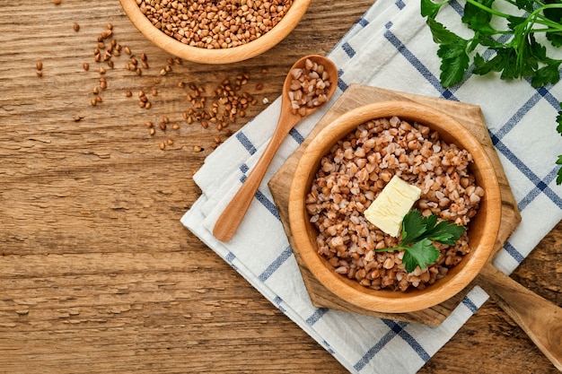 Mingau de trigo sarraceno em uma tigela com folhas de salsa e manteiga